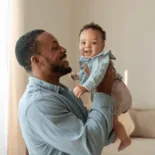 A happy father holding his baby.