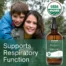 Mother and child smiling outdoors next to bottle of Herb Lore Mullein Tincture with text highlighting respiratory support