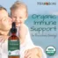 Smiling mother holding toddler at the beach with Herb Lore Echinacea Tincture in the foreground and text saying “Organic Immune Support for the whole family”