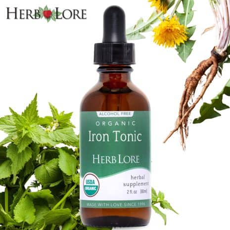 Iron Tonic Tincture Amazon Product Images - Lifestyle Herb Lore Organic Iron Tonic bottle with fresh dandelion root and nettle leaves surrounding it, highlighting key herbal ingredients
