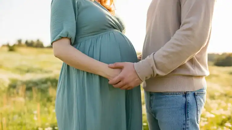 Vickie Pregnant woman and man holding hands outside.